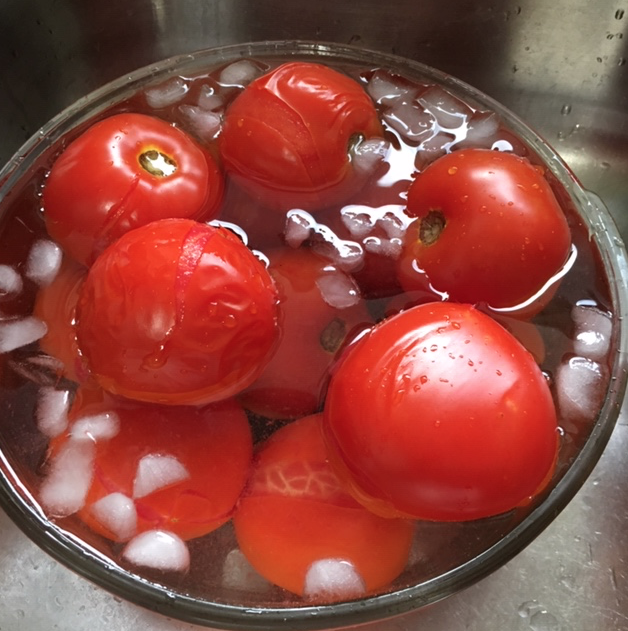 Whole red tomatoes in ice water