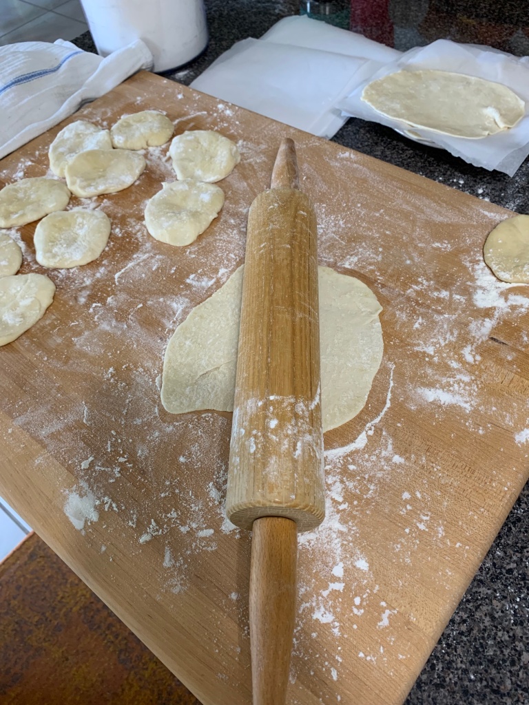 rolling pin tortillas on floured board